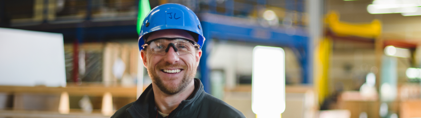 Man in blue hard hat standing on manufacturing floor