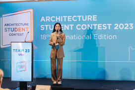 A young woman stands in front of a backdrop that says "Architecture Student Contest 2023" and the podium next to her says USA.