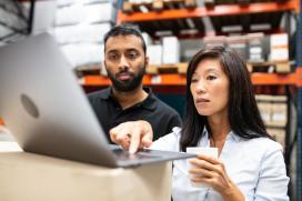A man and woman are looking at a computer screen