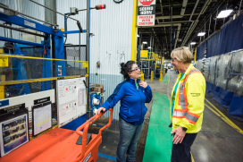 Two women speaking on the manufacturing floor