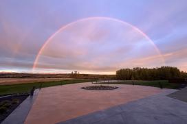 Pigmented concrete is shown on a patio with a rainbow in the background