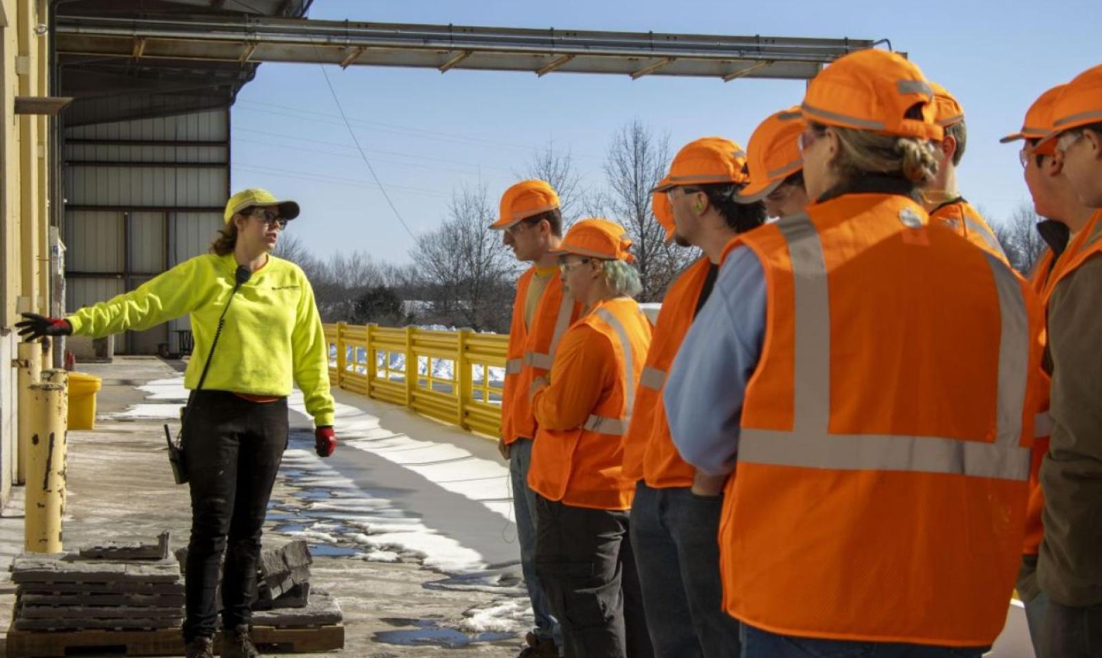 A photo featuring a manufacturing team supervisor showing newcomers what manufacturing and operation jobs look like here in Cleveland, OH, at a Saint-Gobain facility.